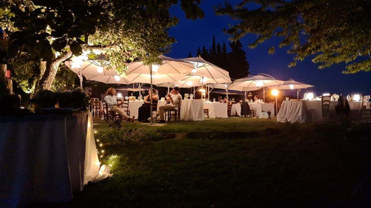 Una cena sotto le stelle all’Osteria Solder: tavoli elegantemente apparecchiati tra ombrelloni illuminati e il verde del giardino. Un’atmosfera magica dove il calore delle luci e la convivialità rendono la serata indimenticabile.
