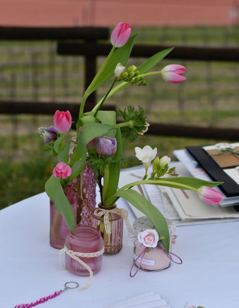Un delicato allestimento floreale all’Osteria Solder: tulipani e fiori di campo in tonalità pastello, raccolti in vasi e candele decorate. Un dettaglio elegante e romantico che arricchisce la tavola con semplicità e raffinatezza.