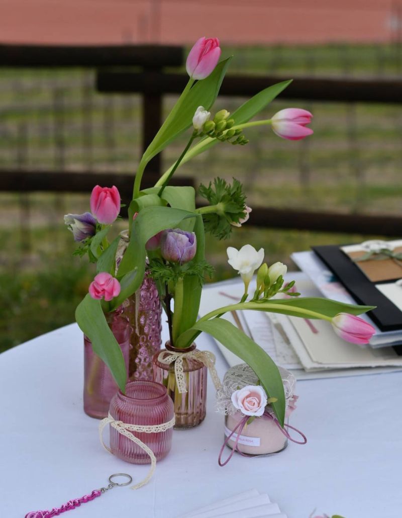 Un delicato allestimento floreale all’Osteria Solder: tulipani e fiori di campo in tonalità pastello, raccolti in vasi e candele decorate. Un dettaglio elegante e romantico che arricchisce la tavola con semplicità e raffinatezza.